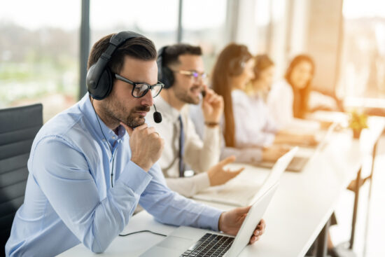 Pensive agent operator using laptop at call center office