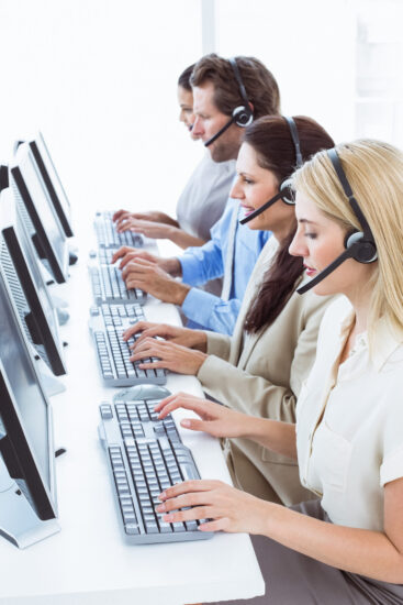 Business people with headsets using computers in office